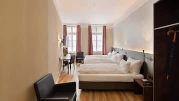 Ein Hotelzimmer mit zwei Betten, einem Schreibtisch und einem Stuhl.