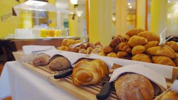 Een buffet met verschillende gebakjes, waaronder croissants en brood.