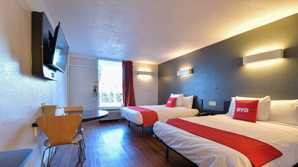 Una habitación de hotel con dos camas, un escritorio y una silla.