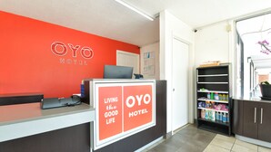 Una recepción con un cartel que dice "OYO HOTEL" y "VIVIENDO LA BUENA VIDA".