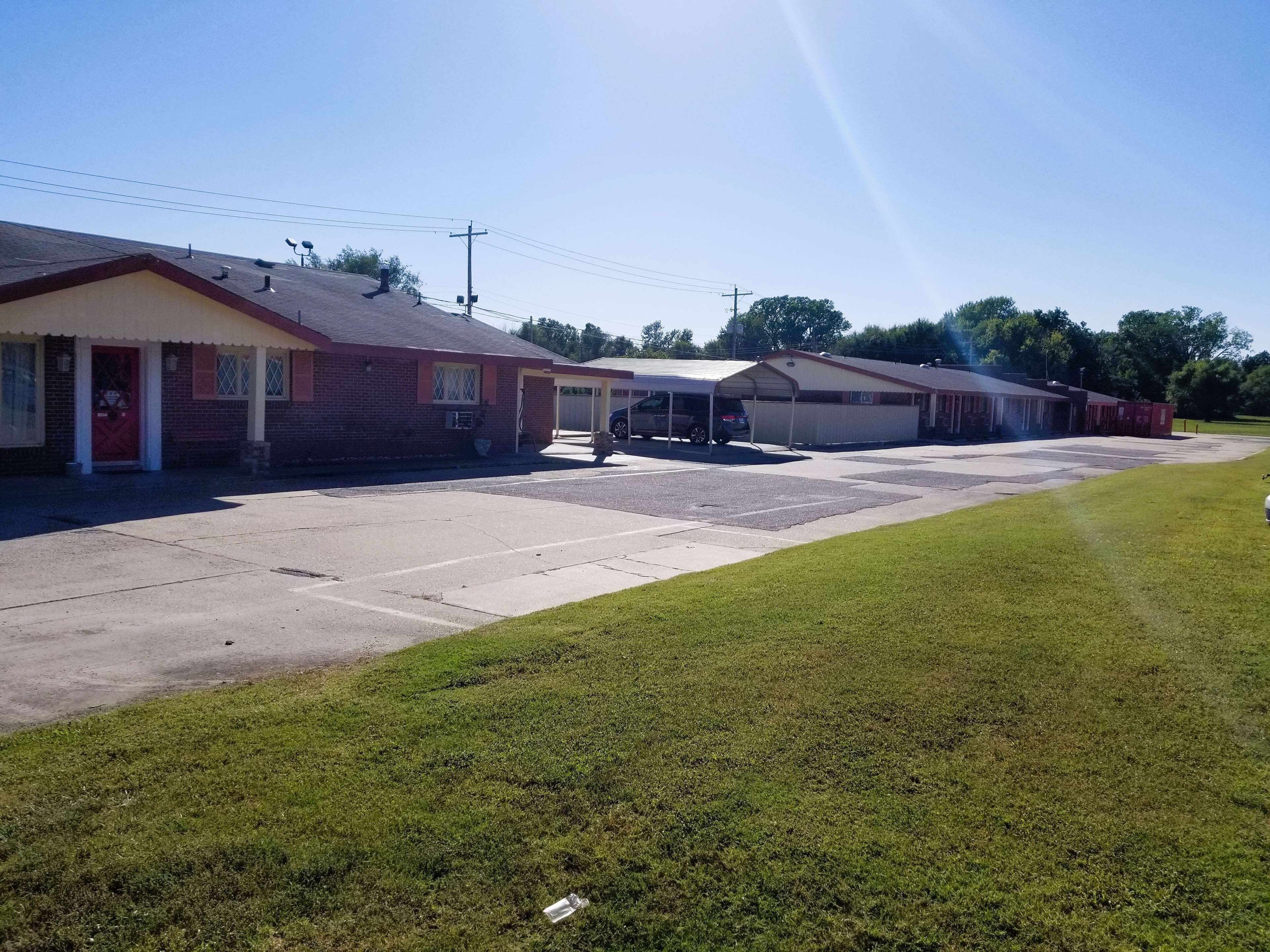 A row of single-story buildings with a covered parking area.