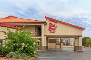 A Red Roof Inn with a red roof, beige walls, and a parking lot. - Red Roof Inn Bowling Green (Bowling Green)