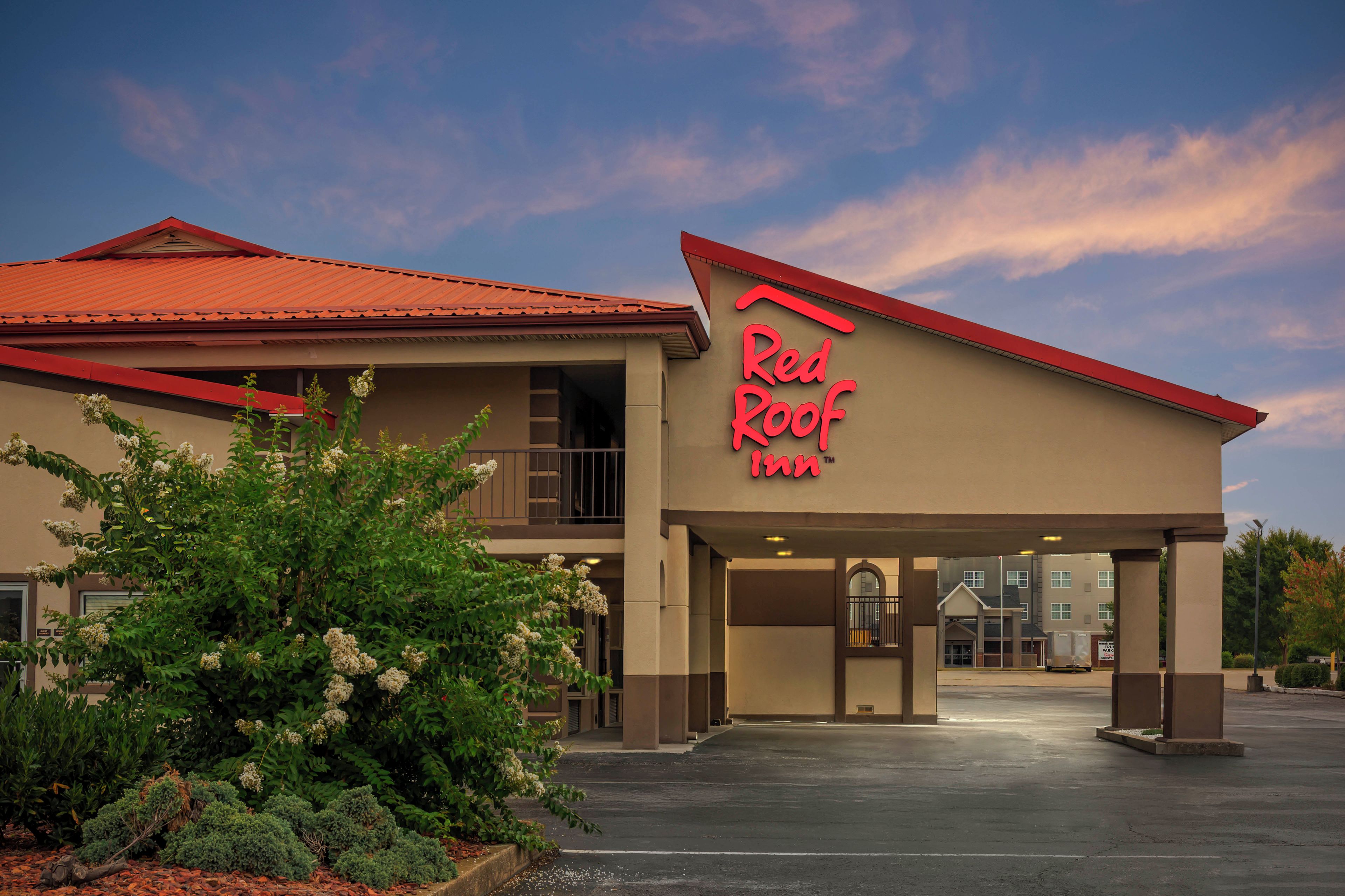 Ein Red Roof Inn mit rotem Dach und einem Schild über dem Eingang.