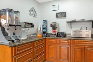 A kitchen with a coffee machine, a frosted flake cereal dispenser, and a sign indicating food is to be eaten only in the dining area. - Red Roof Inn Bowling Green (Bowling Green)