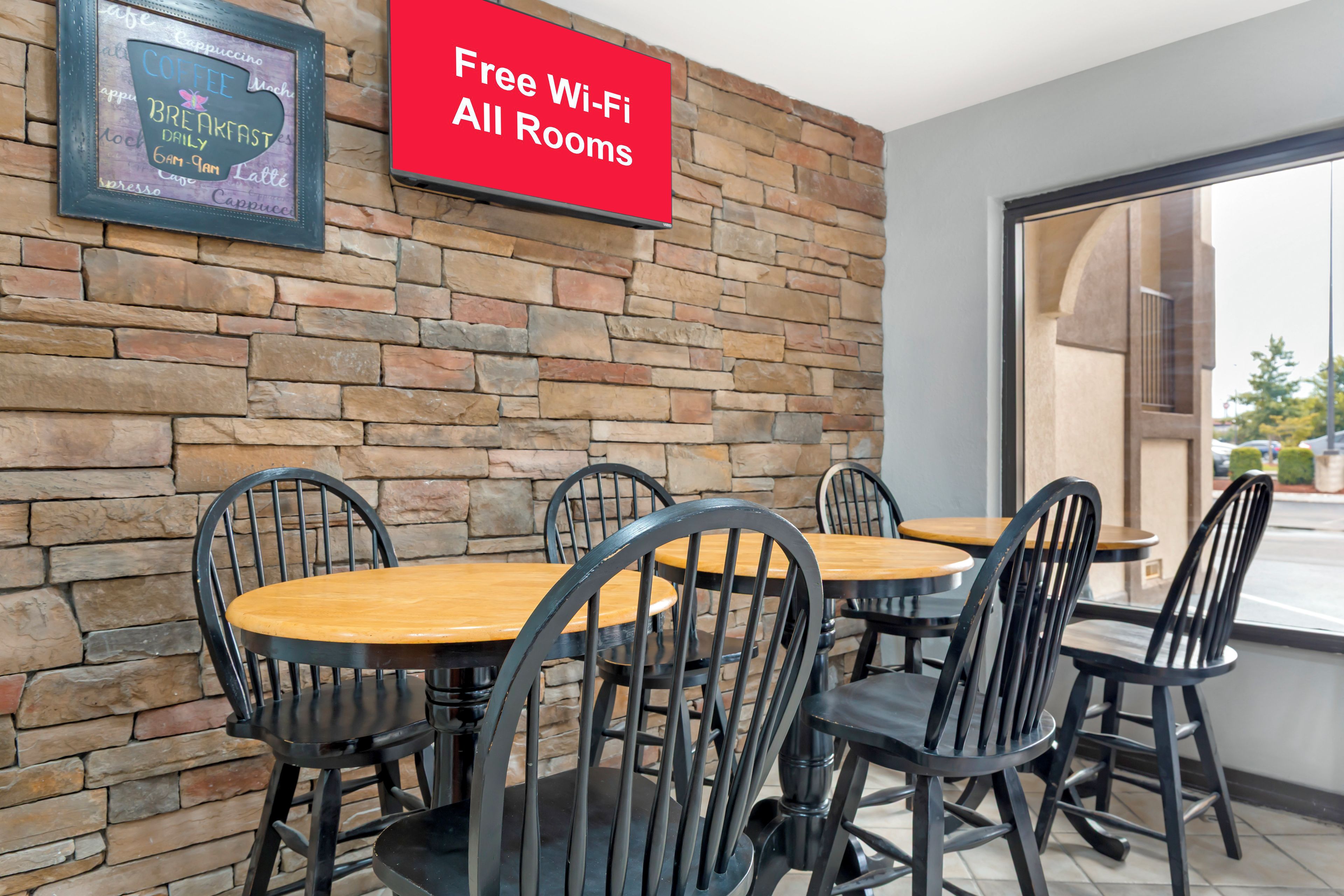 A cafe with a stone wall, a sign for free Wi-Fi, and a chalkboard menu.