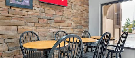 A cafe with a stone wall, a sign for free Wi-Fi, and a chalkboard menu.