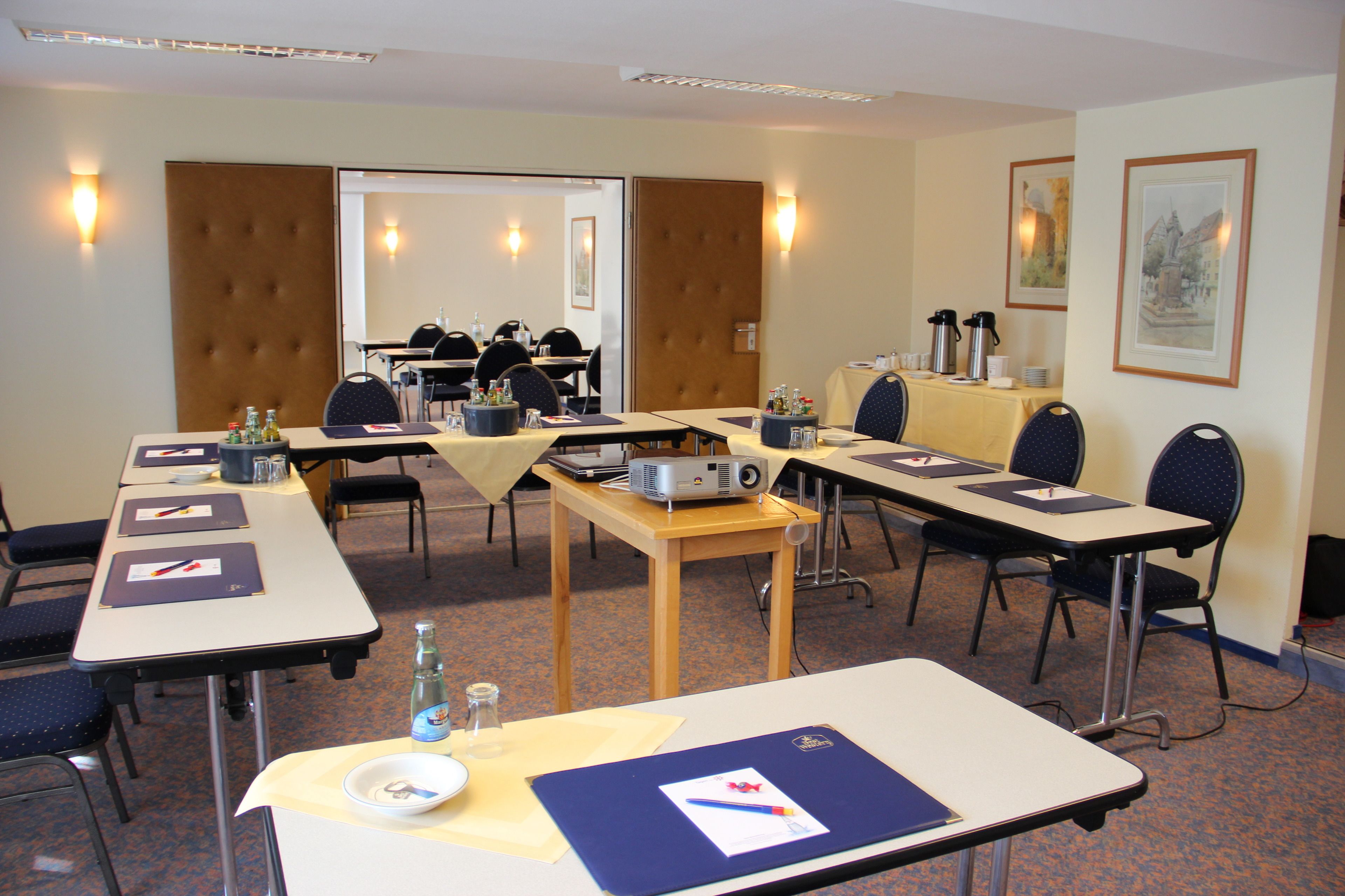 A conference room with tables, chairs, and presentation equipment.