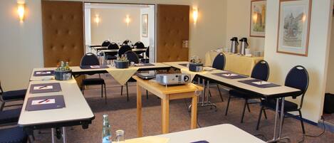 A conference room with tables, chairs, and presentation equipment.