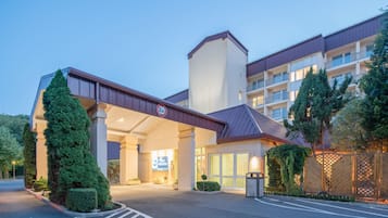 Entrada de un hotel con un paseo techado, un letrero que indica un límite de altura de 3,5 metros y un cartel de Best Western.