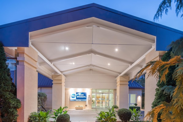 A hotel entrance with a clear sign, a covered walkway, and well-maintained landscaping. - Best Western Hotel Jena (Jena)