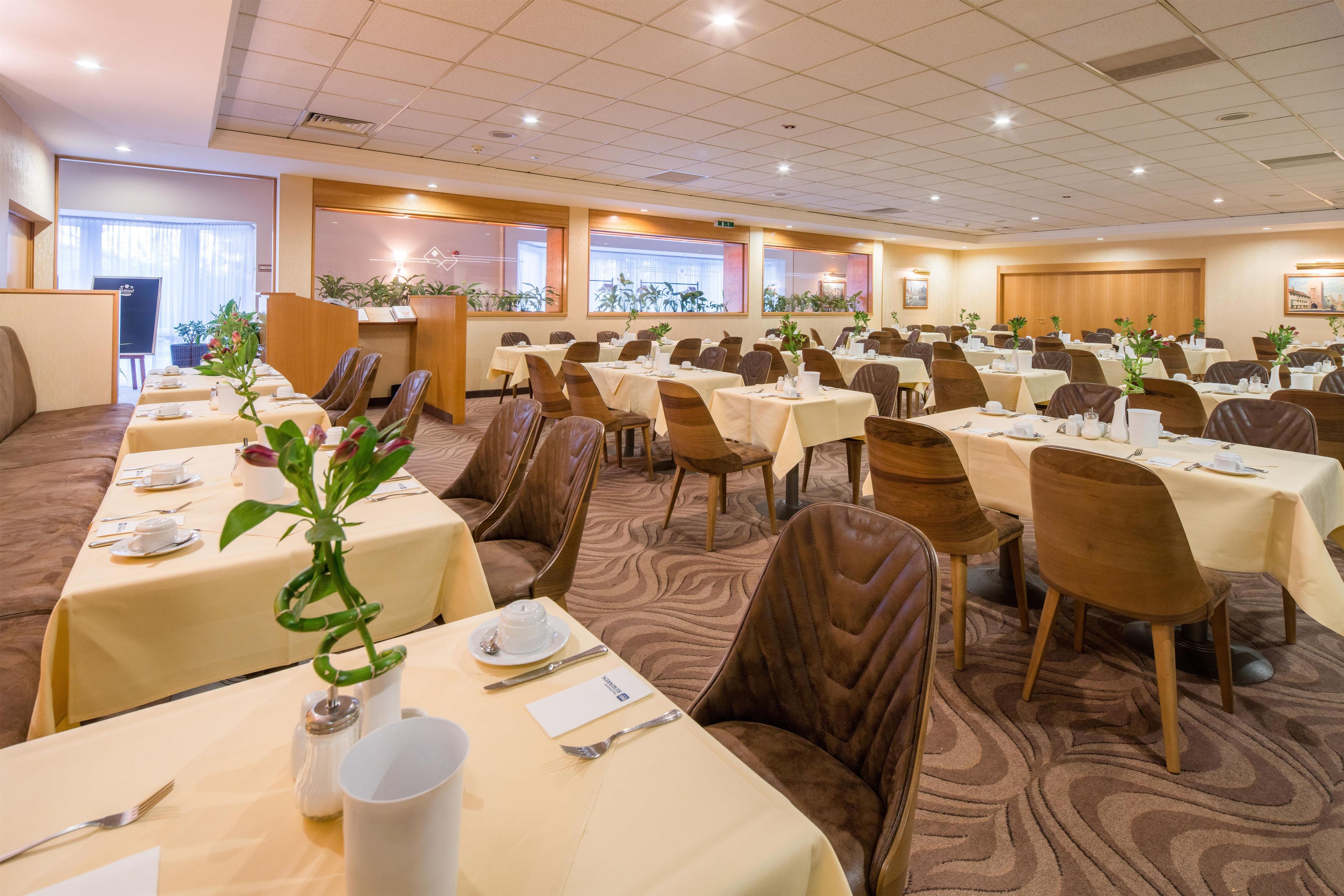 A conference room with multiple tables and chairs, arranged for a meeting or event.