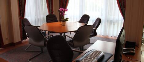 Une salle de conférence équipée d’une table, de chaises, d’un ordinateur et d’un clavier.
