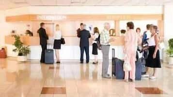 Ein Hotel-Empfangsbereich mit Check-in-Schalter, Wartebereich und Rezeption.