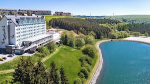 A hotel with a large building, a lake, and a forested area. - Best Western Ahorn Hotel Oberwiesenthal - Adults Only (Oberwiesenthal)