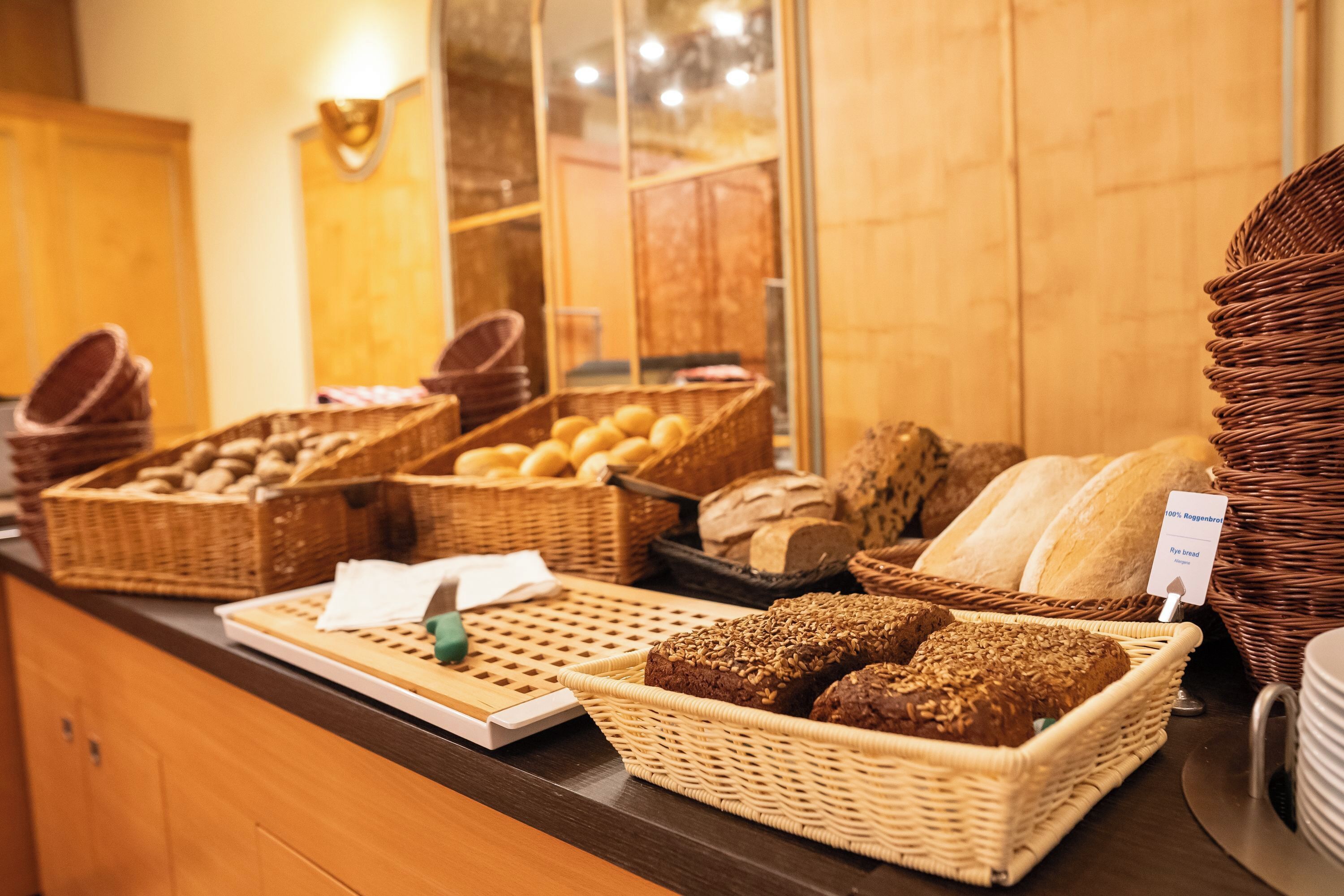 Una vitrina de panadería con panes y pasteles varios.