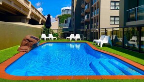 Alberca al aire libre y camastros