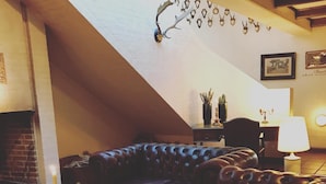 Un salon chaleureux avec un canapé en cuir, une cheminée et une table à manger.