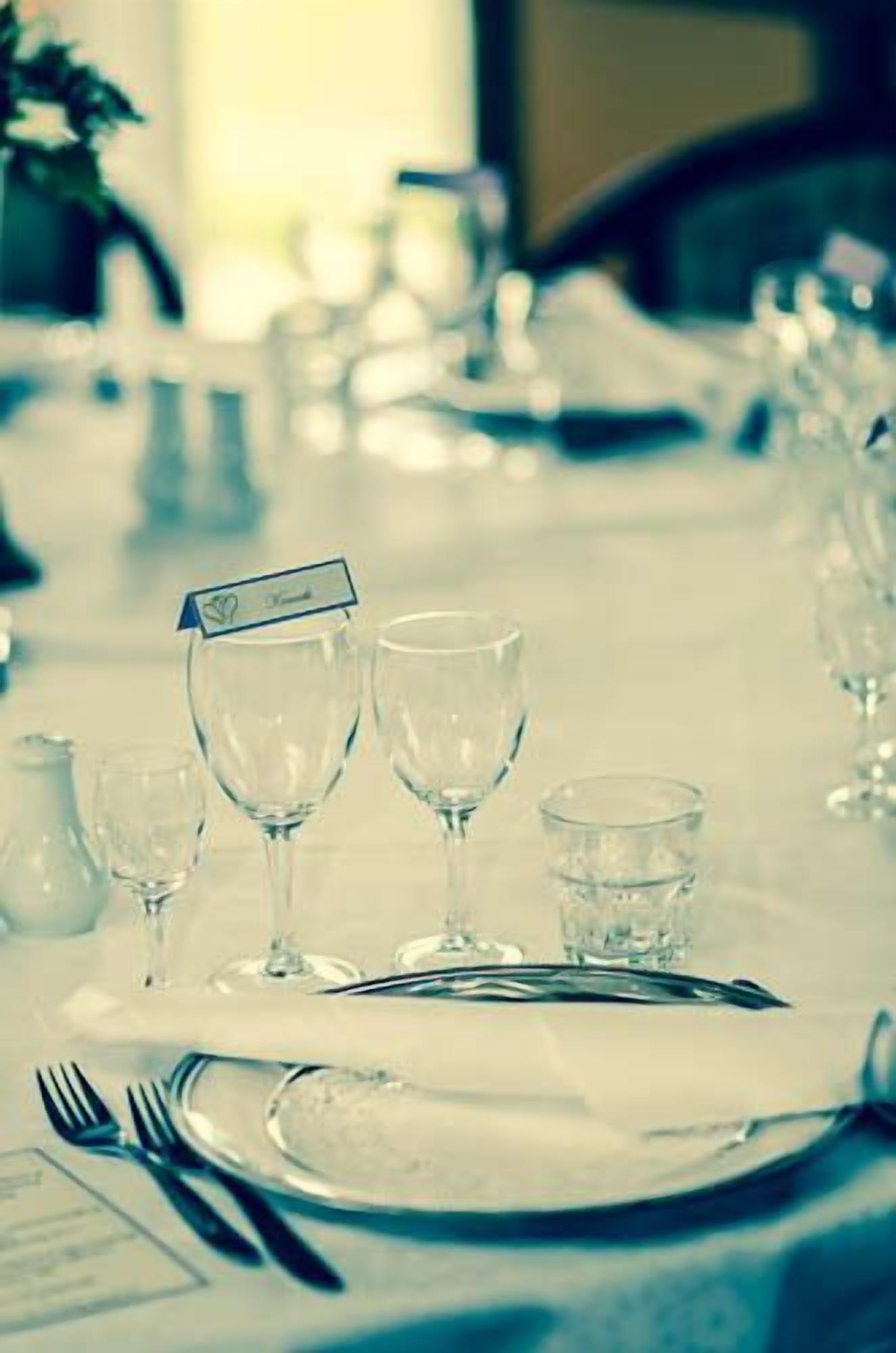 A table set for dining with wine glasses, a water glass, and cutlery.