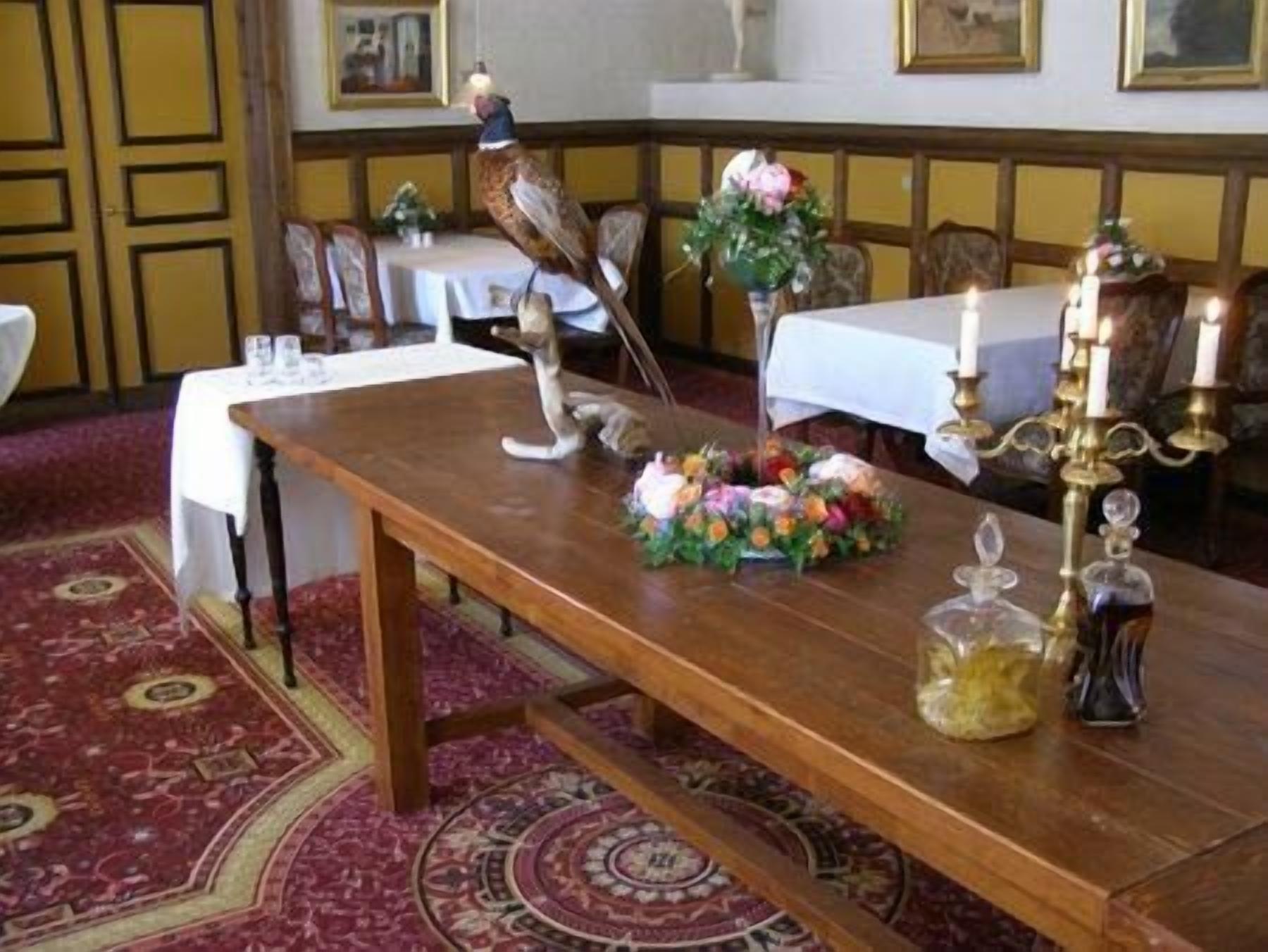 A dining table with a floral centerpiece, a candelabra, and a bird sculpture.