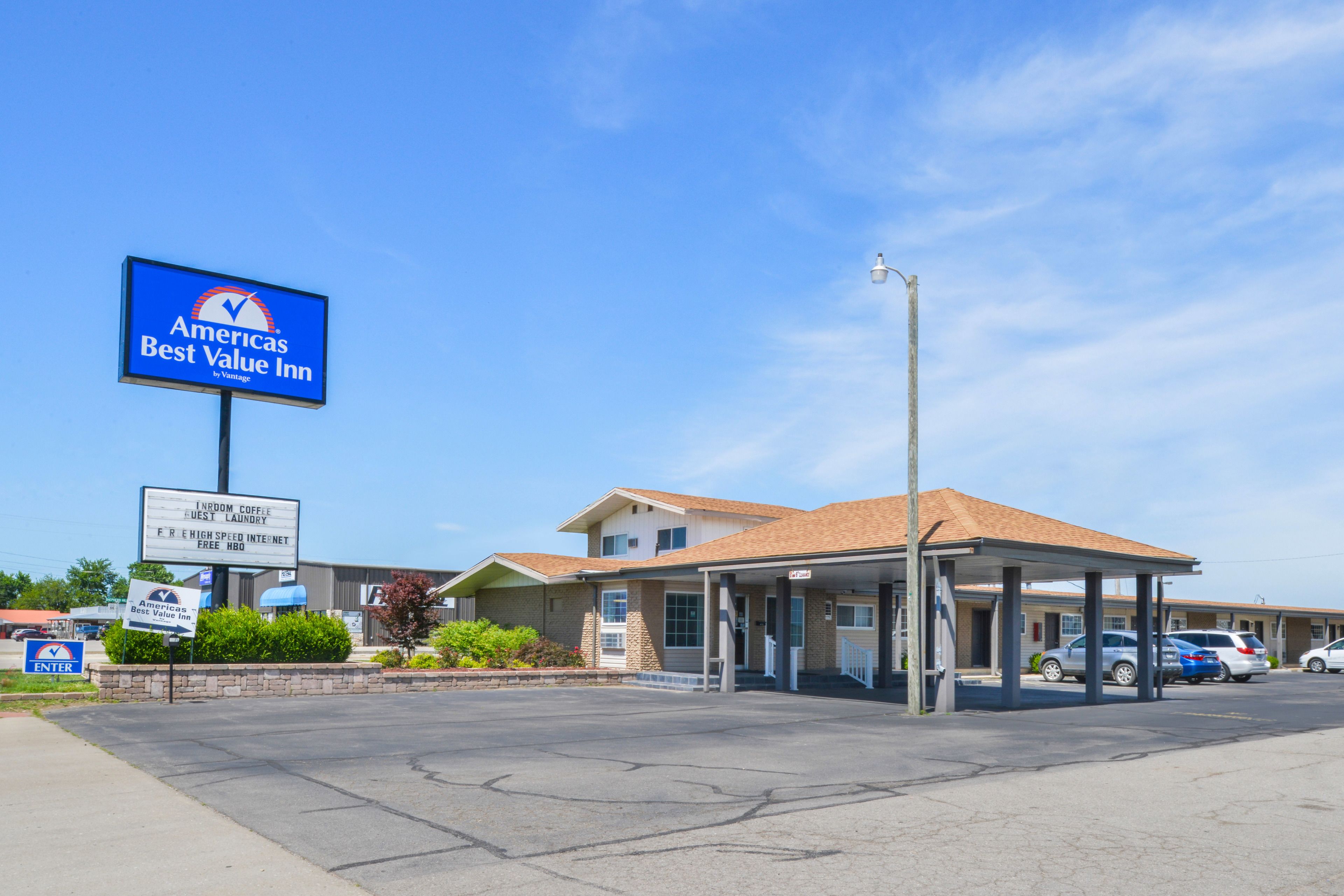 Een motel met een bord 'Americas Best Value Inn' en voorzieningen zoals gratis koffie, een wasserette en snelle internetverbinding.