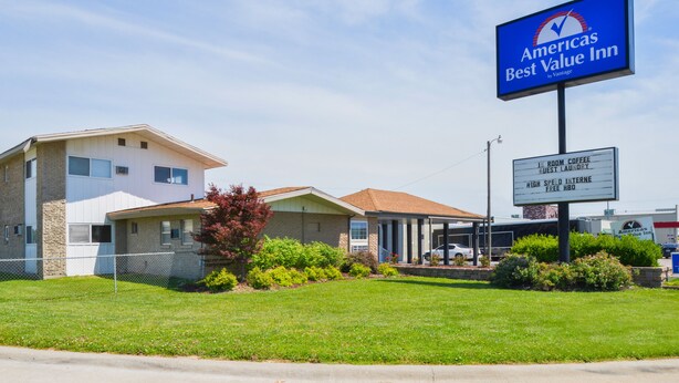 A Best Value Inn with a sign indicating amenities like room coffee, guest laundry, high-speed internet, and free breakfast.