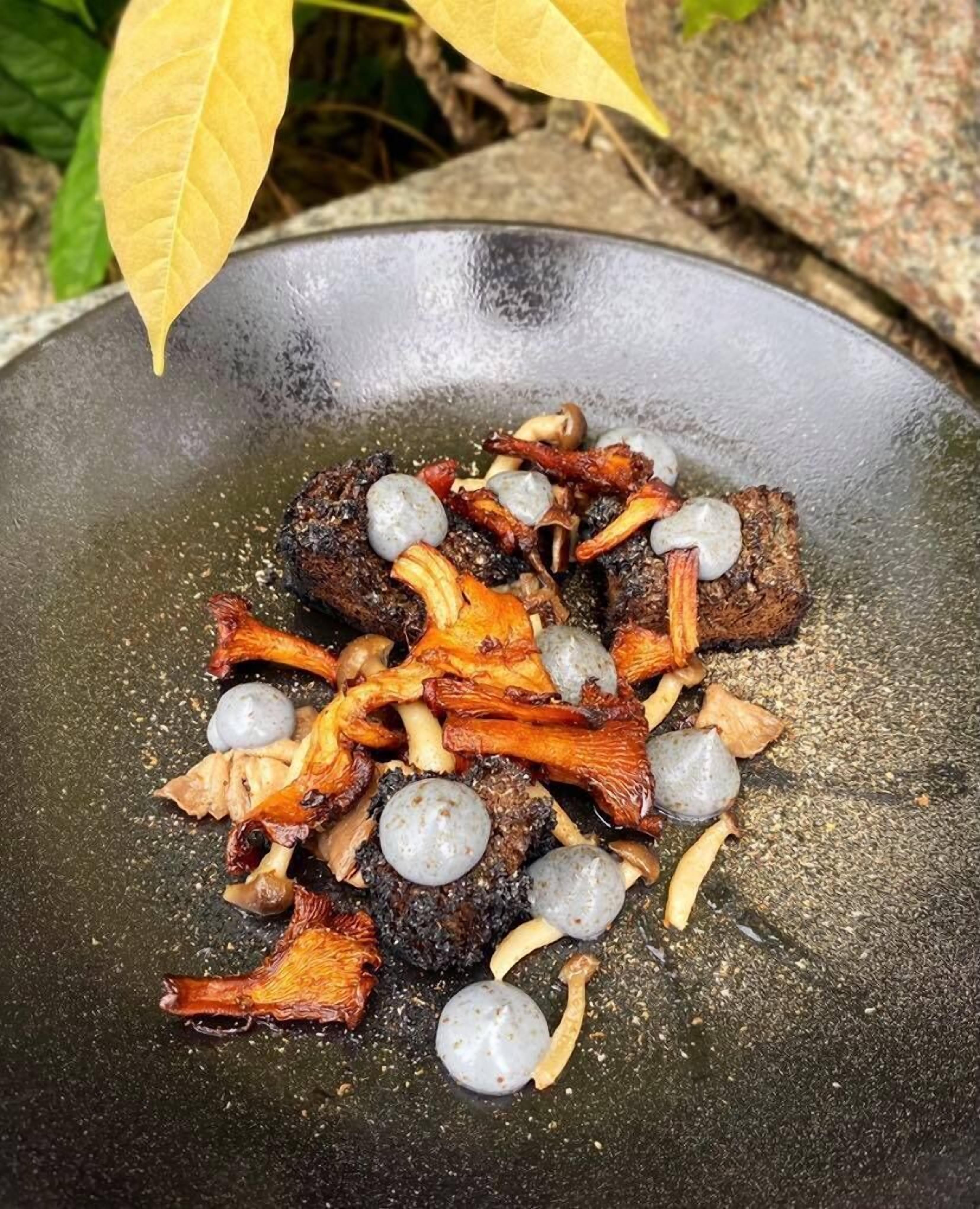 Un wok contenant de la viande cuite, des champignons et des boulettes d’œufs.