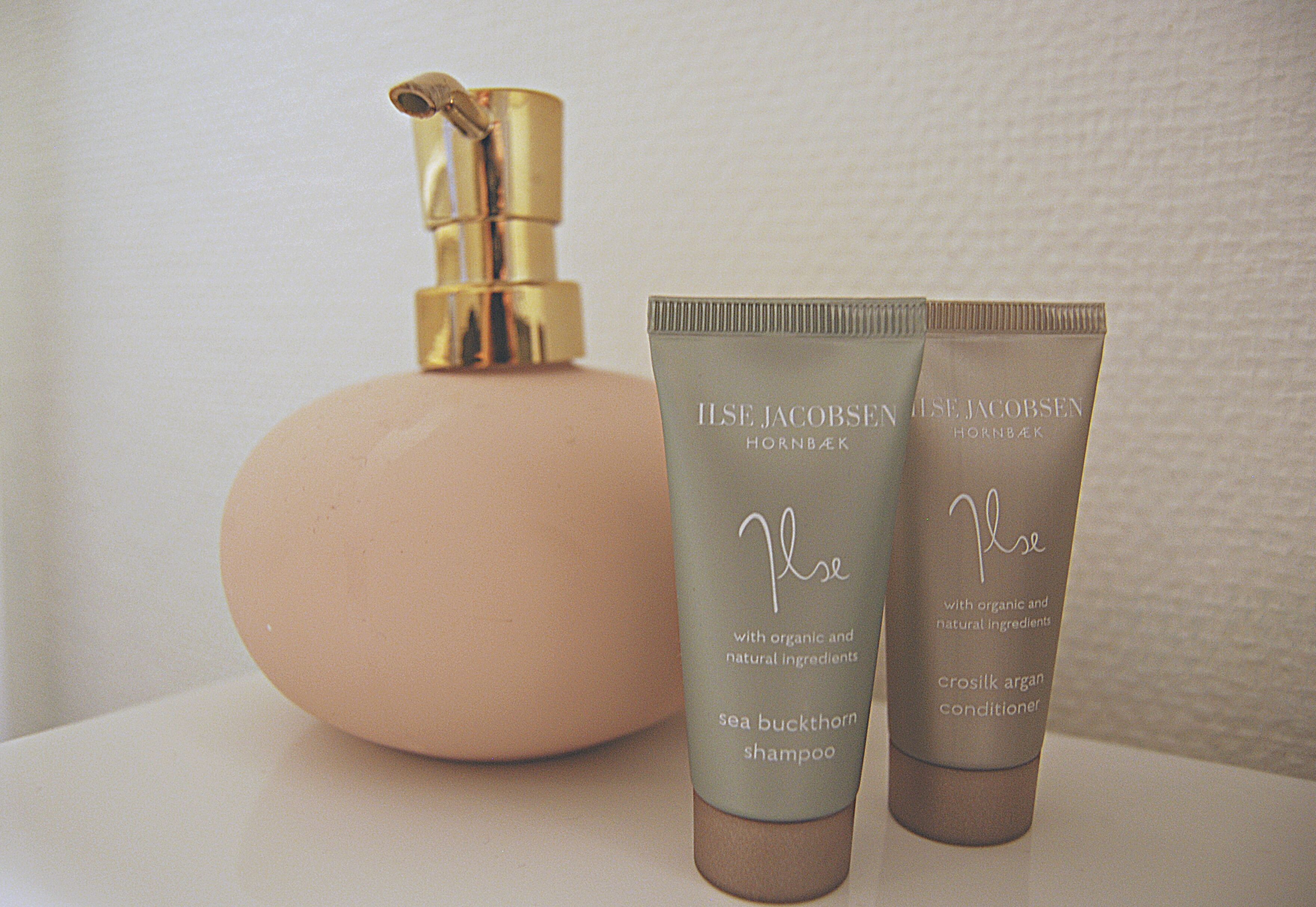 A cosmetic product display with a pump bottle and two tubes of Ilse Jacobsen cream.