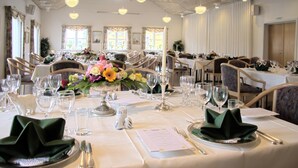 A dining area with tables set for a meal, complete with cutlery, glasses, and floral centerpieces. - Hotel Hovborg Kro (Hovborg)