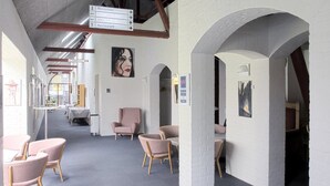 A hotel lobby with a reception desk, a restaurant, and a restroom. There are chairs and tables arranged for guests. - Hotel Hovborg Kro (Hovborg)