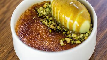 Un postre en un tazón blanco sobre una mesa de madera.