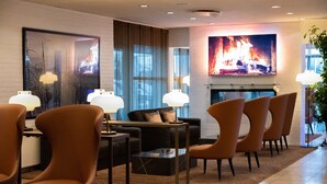 A modern living room with a fireplace, comfortable seating, and a large TV screen. - Hotel Svanen, Stays & BW Signature Collection (Billund)
