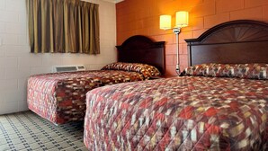 Quarto de hotel com duas camas, parede de tijolos, janela com cortinas e luminária presa à parede.