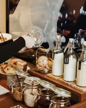A buffet setup with various food items and condiments. - Hotel Miro (Bilbao)