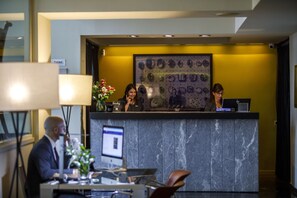 A reception desk with a marble counter, a computer, and a framed artwork on the wall. - Hotel Miro (Bilbao)