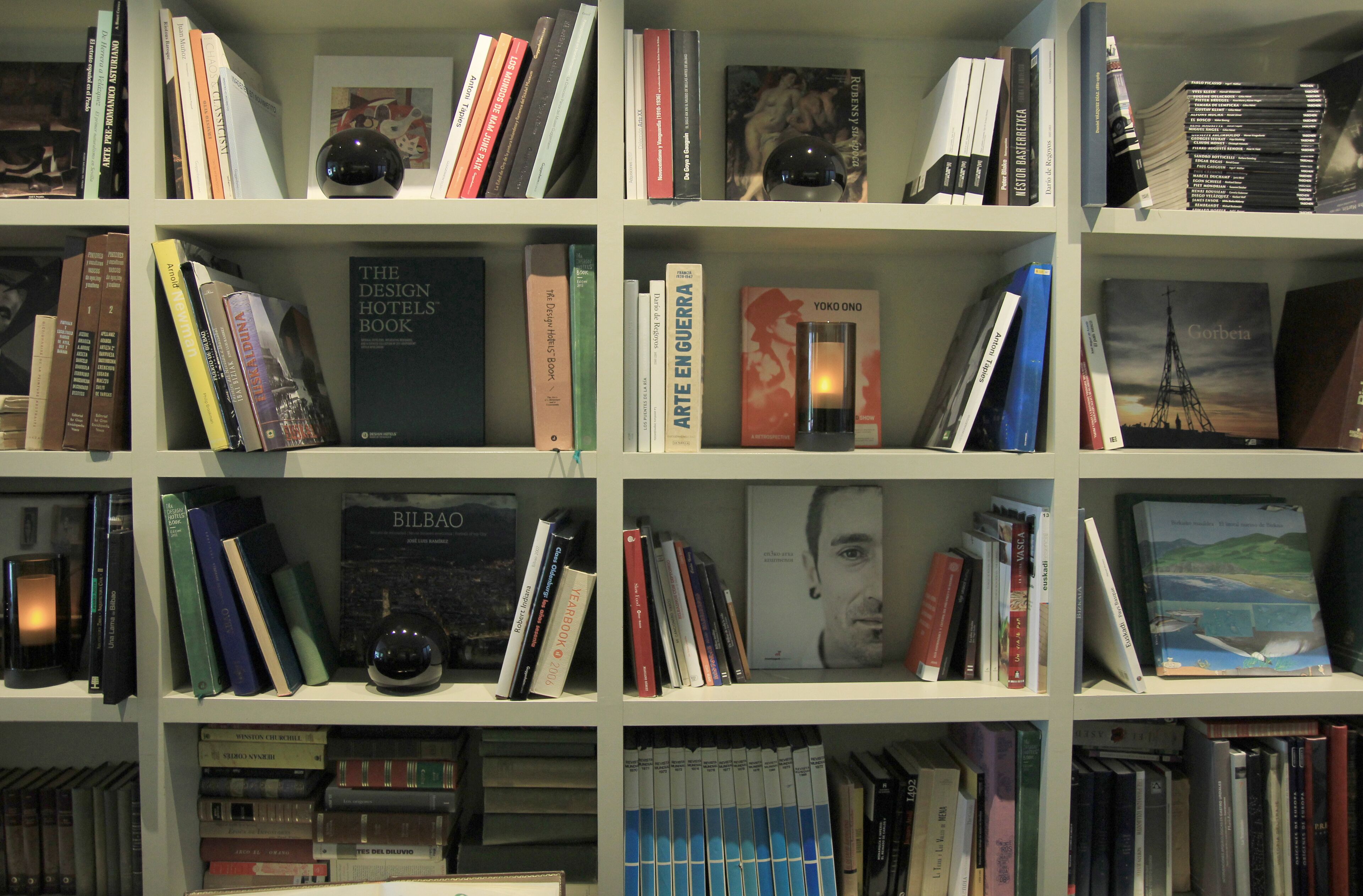 Una estantería repleta de libros diversos y un globo terráqueo.