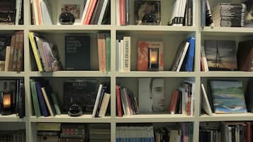 Una estantería repleta de libros diversos y un globo terráqueo.
