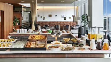 A buffet setup with various food items and beverages.