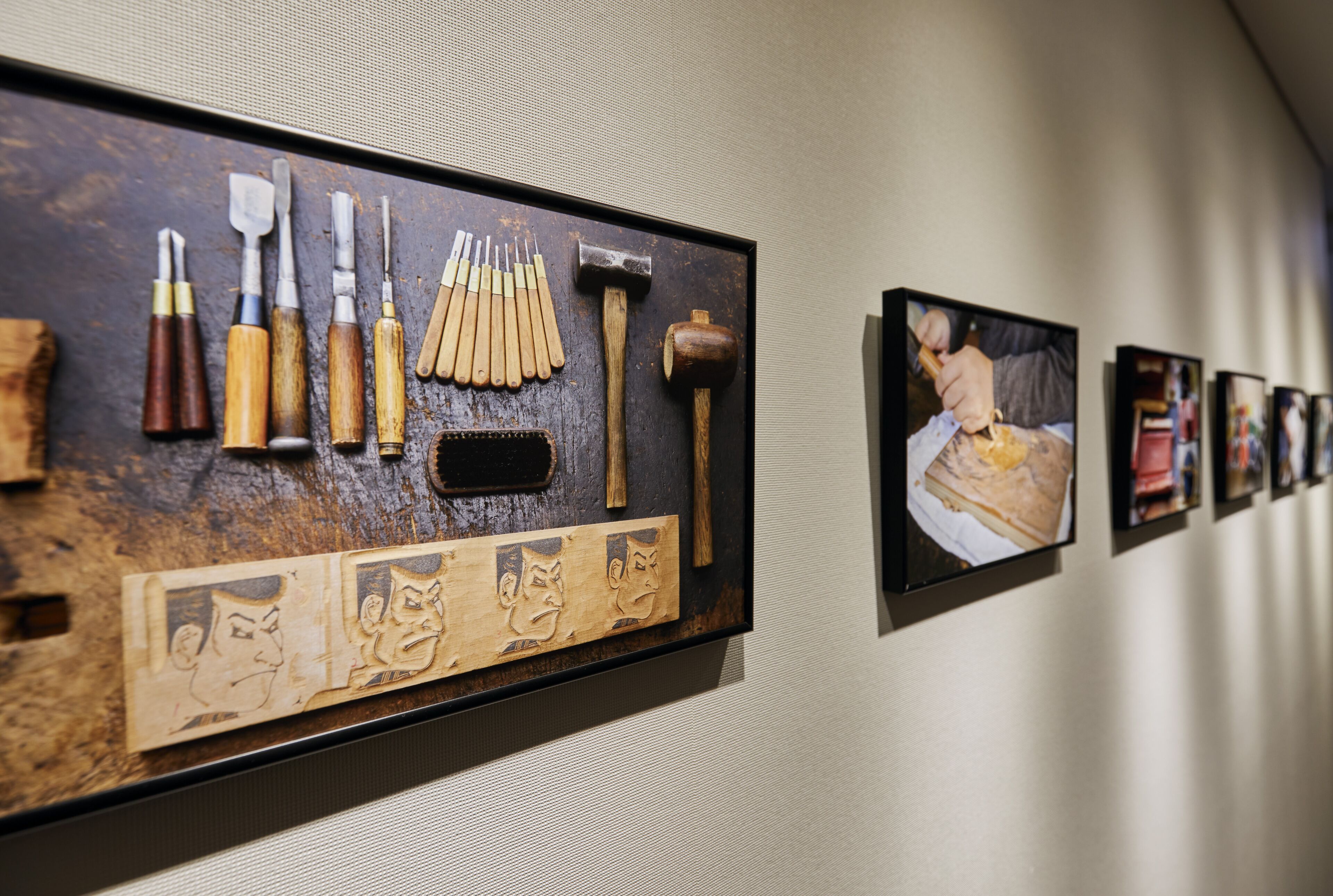 A display of woodworking tools and a framed artwork on a wall.
