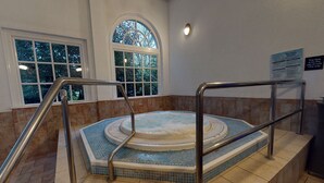 A hot tub with metal railings, a tiled floor, and a window with a view of trees. - Village Hotel St David's, Nr Chester (Deeside)