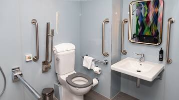 Un bagno moderno con servizi igienici, bidet, asciugamani ad aria e lavandino.