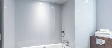 Une salle de bain moderne avec une baignoire, des toilettes et un meuble-lavabo en bois.