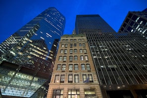 A hotel with a classic facade, modern glass skyscrapers in the background, and a sign indicating its location on Wall Street. - Eurostars Wall Street (New York)