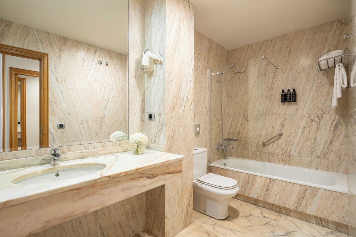 bathtub, eco-friendly toiletries, hair dryer, towels