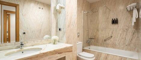 Un baño con lavamanos, inodoro y bañera de mármol.