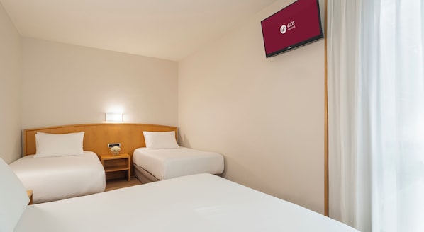 A hotel room with two single beds, a bedside table with a lamp, and a TV mounted on the wall. - Exe Area Central (Santiago de Compostela)