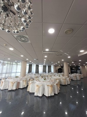 A spacious hall with round tables, white tablecloths, and gold sashes. - Sercotel Tudela Bardenas (Tudela)