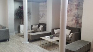 A modern living room with grey sofas, a coffee table, and a large potted plant. - Sercotel Tudela Bardenas (Tudela)