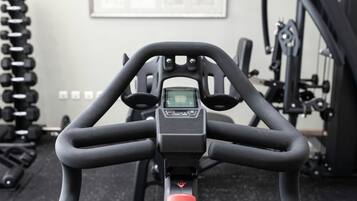 Una bicicleta estàtica amb pantalla digital i un botó d'aturada vermell.