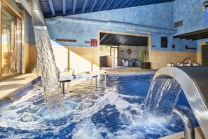 Ein Whirlpool mit Wasserdüsen, ein gefliester Boden und ein Schild, das einen 100% natürlichen Pool kennzeichnet.