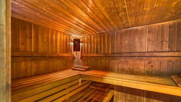 Una sauna con bancos de madera y una unidad de calefacción central.